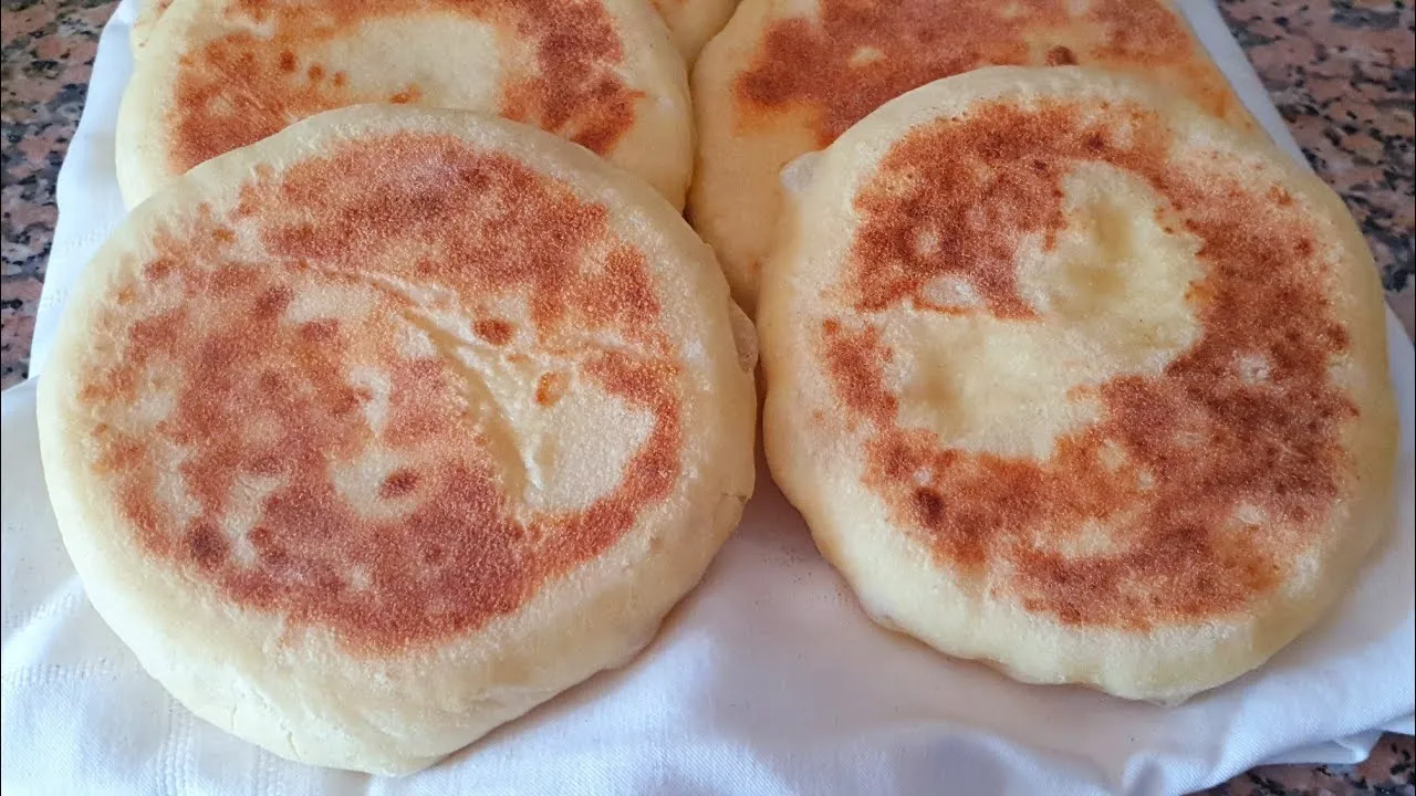 Two brown and white pancakes on a white cloth.