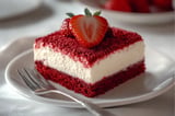 A slice of red velvet cake with strawberries on top.