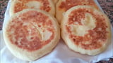 Two brown and white pancakes on a white cloth.