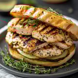 A grilled chicken sandwich with herbs.