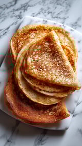 A stack of pancakes on a plate.
