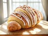 A pastry with white icing and nuts on top.
