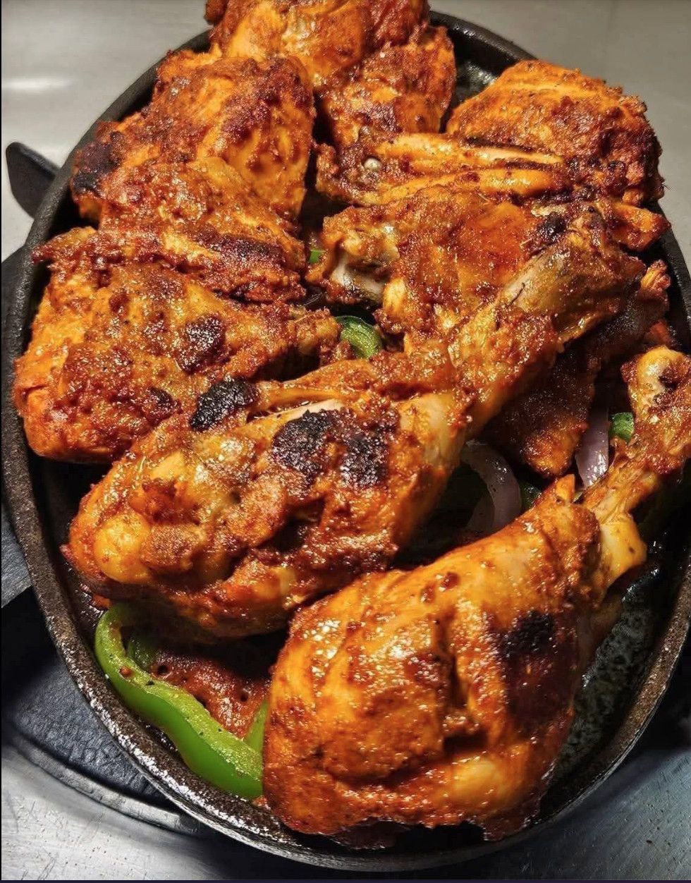 A pan of chicken with peppers and onions.