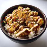 A bowl of food with sauce on top.