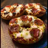 Two pepperoni pizza bagels on a blue plate.
