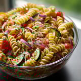 A bowl of pasta with vegetables.