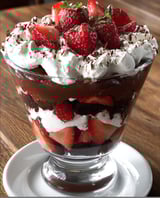 A glass of chocolate and strawberry dessert.