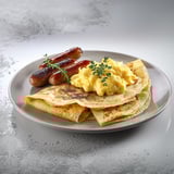 A plate of food with eggs, sausage, and pancakes.