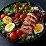 A bowl of food with eggs, tomatoes, and meat.