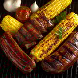 A grilled sausage and corn on the cob.